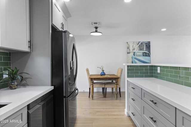 6723 E 1st Ave, Scottsdale, AZ 85251 - kitchen with refrigerator with ice dispenser, backsplash, light countertops, light wood-style floors, and recessed lighting