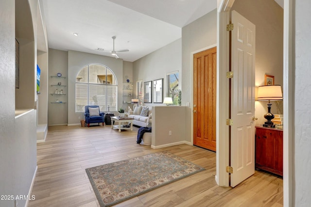 foyer featuring ceiling fan, baseboards, and wood finished floors