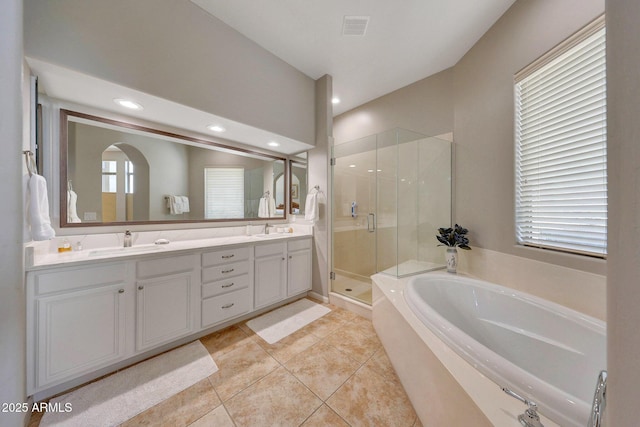 full bathroom featuring a bath, a stall shower, visible vents, and a sink