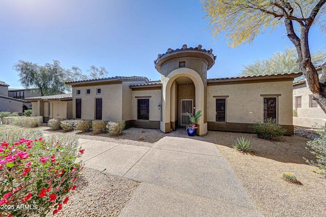 mediterranean / spanish-style house featuring a tiled roof and stucco siding