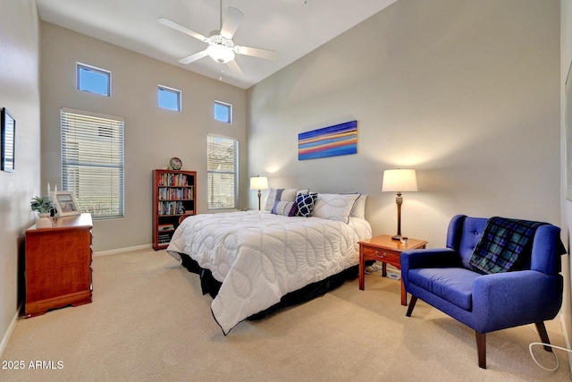 bedroom featuring a ceiling fan, carpet, a towering ceiling, and baseboards