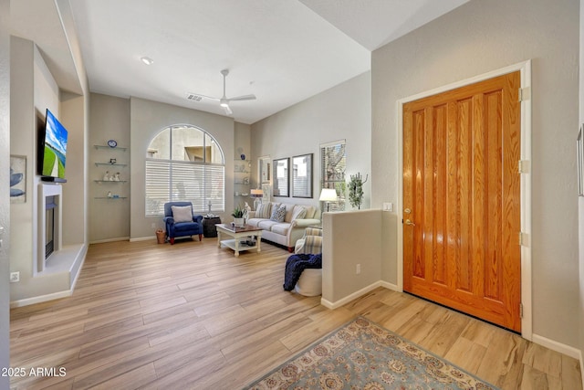 entryway with visible vents, vaulted ceiling, baseboards, and wood finished floors