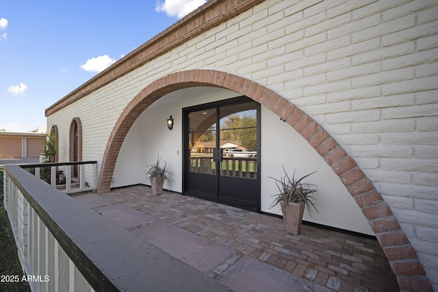 view of exterior entry featuring a patio area