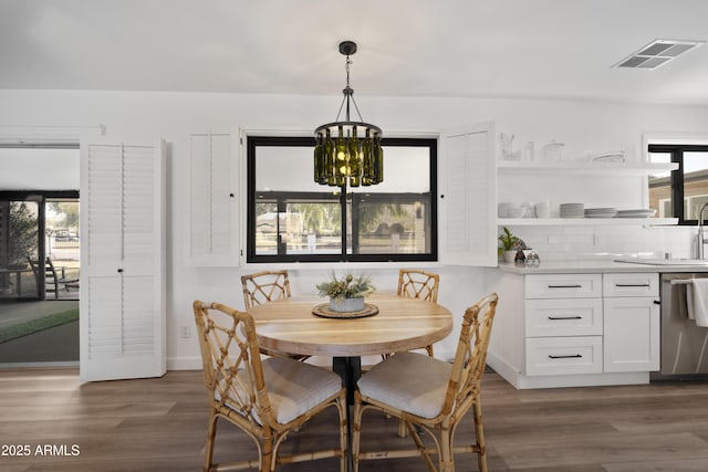 dining space featuring sink, a chandelier, and dark hardwood / wood-style flooring