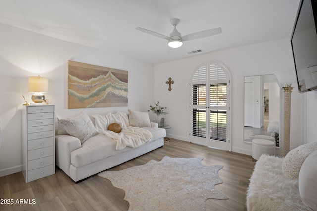 living room with light hardwood / wood-style flooring and ceiling fan