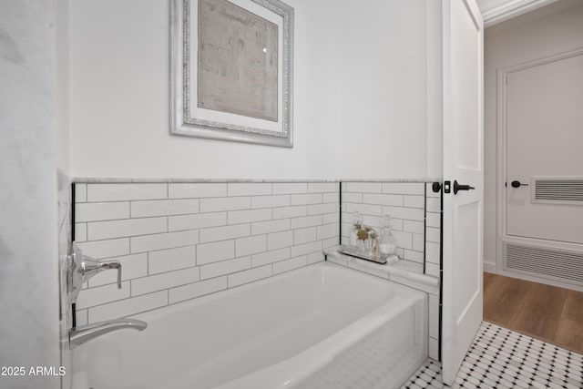 bathroom with tile patterned flooring and a tub