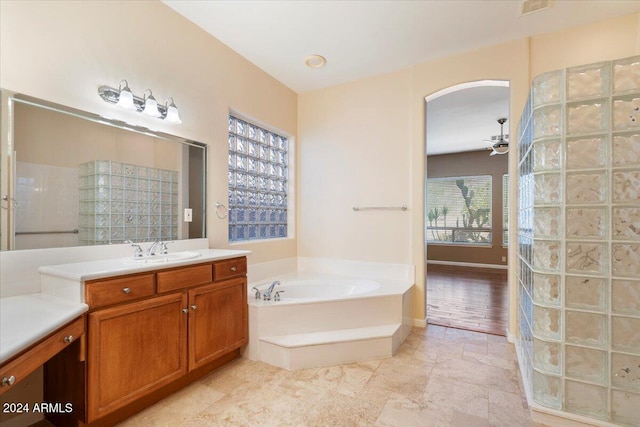 bathroom with a healthy amount of sunlight, ceiling fan, vanity, and separate shower and tub