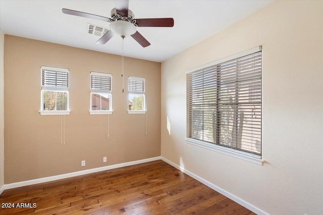 spare room featuring wood-type flooring, ceiling fan, and a healthy amount of sunlight