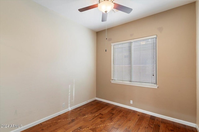 empty room featuring a healthy amount of sunlight, ceiling fan, and hardwood / wood-style flooring