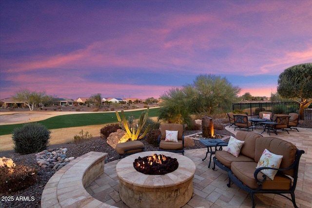 patio terrace at dusk with an outdoor living space with a fire pit