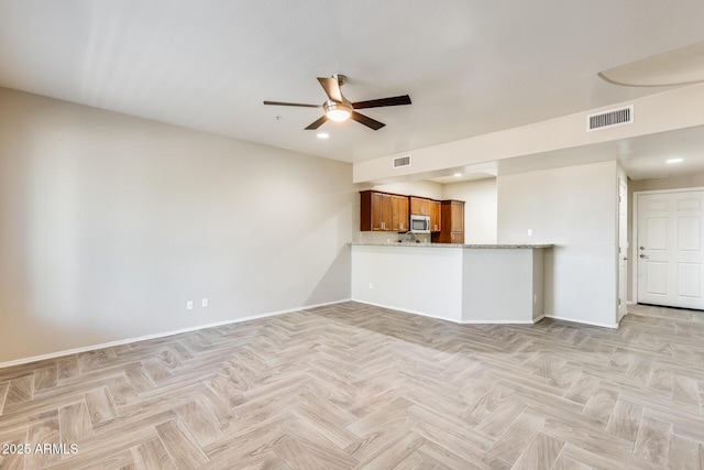 unfurnished living room with ceiling fan and light parquet flooring