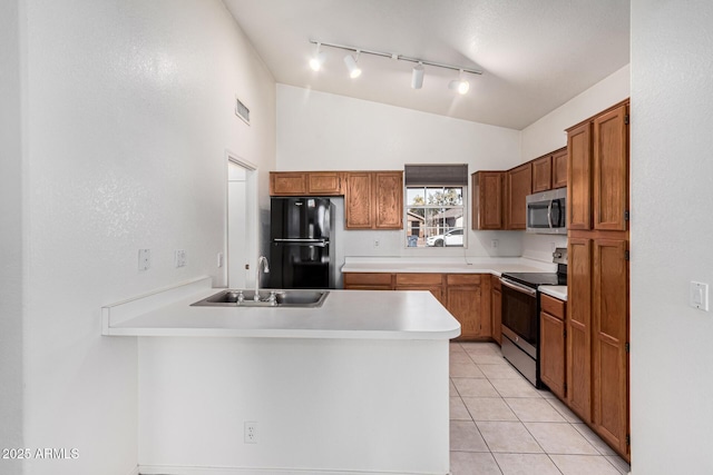 kitchen featuring sink, vaulted ceiling, light tile patterned floors, kitchen peninsula, and stainless steel appliances