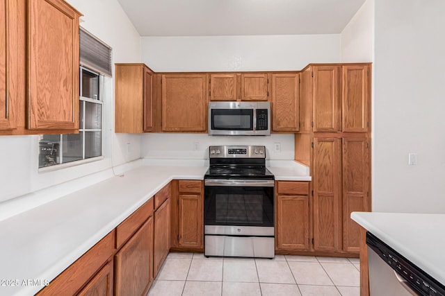 kitchen with stainless steel appliances and light tile patterned flooring