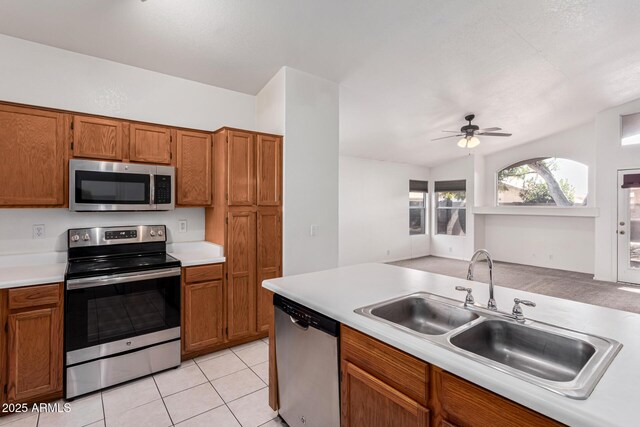 kitchen with sink, light tile patterned floors, stainless steel appliances, and ceiling fan