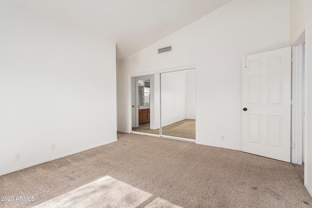 unfurnished bedroom with carpet flooring, high vaulted ceiling, and a closet