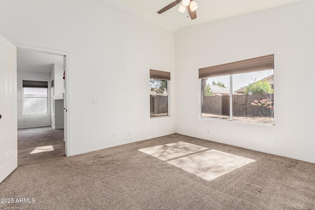 carpeted empty room featuring ceiling fan and vaulted ceiling