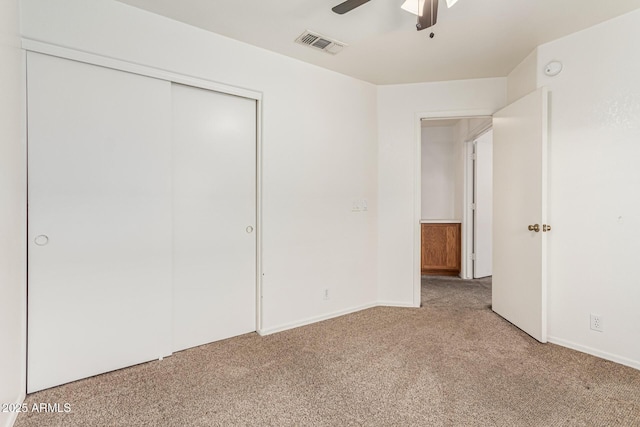 unfurnished bedroom with light carpet, a closet, and ceiling fan