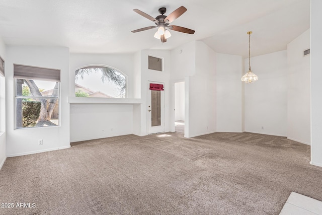 unfurnished living room featuring vaulted ceiling, carpet flooring, and ceiling fan with notable chandelier