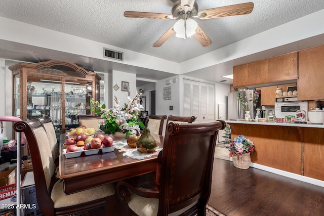 dining area featuring a textured ceiling, ceiling fan, and hardwood / wood-style flooring