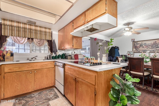 kitchen with kitchen peninsula, a healthy amount of sunlight, a textured ceiling, black electric cooktop, and sink