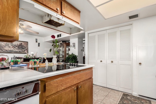 kitchen featuring white dishwasher, ceiling fan, light tile patterned floors, and black electric cooktop