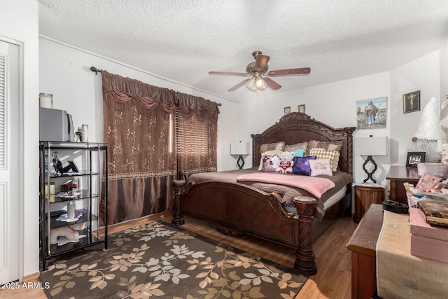 bedroom with a textured ceiling, ceiling fan, and wood-type flooring