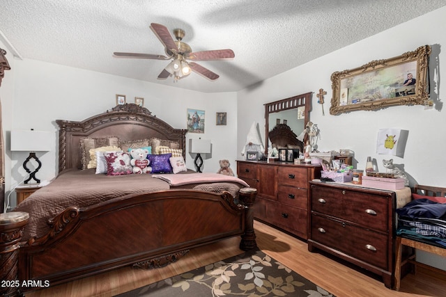 bedroom featuring a textured ceiling, ceiling fan, and light wood-type flooring