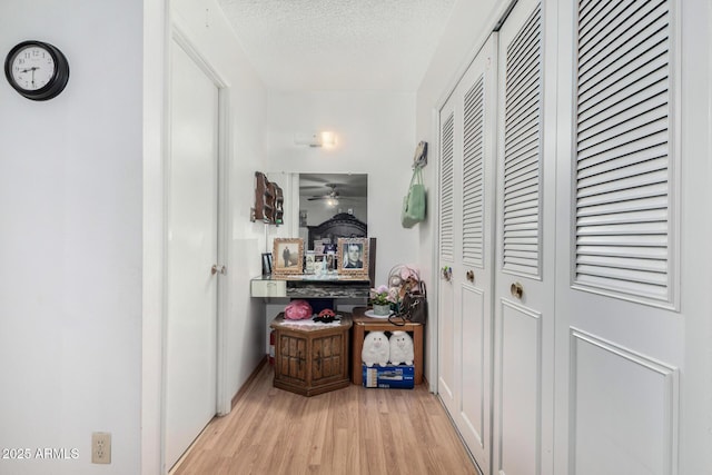 hall featuring a textured ceiling and light wood-type flooring