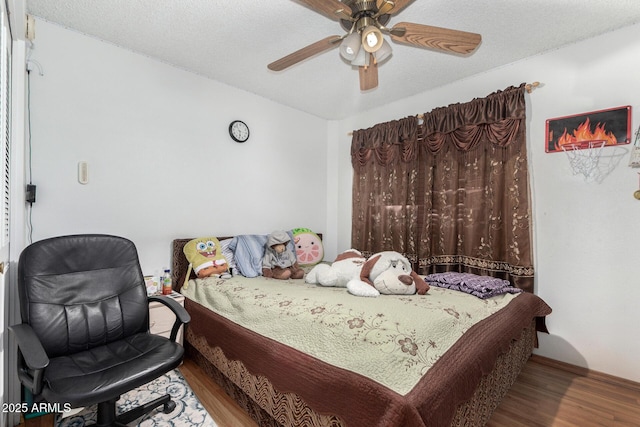 bedroom featuring ceiling fan, hardwood / wood-style floors, and a textured ceiling