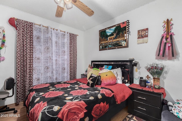 bedroom featuring a textured ceiling, ceiling fan, and wood-type flooring