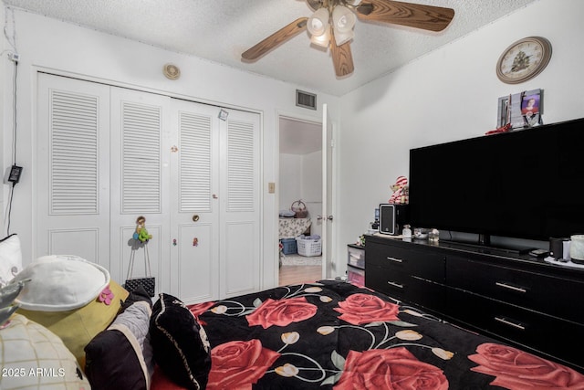 bedroom featuring a textured ceiling, ceiling fan, and a closet