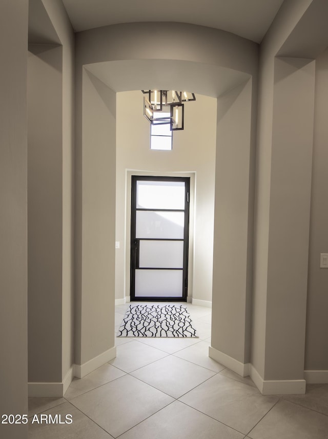 interior space with light tile patterned floors and a notable chandelier