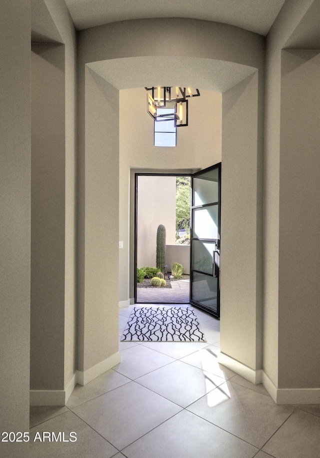 foyer with light tile patterned floors and an inviting chandelier