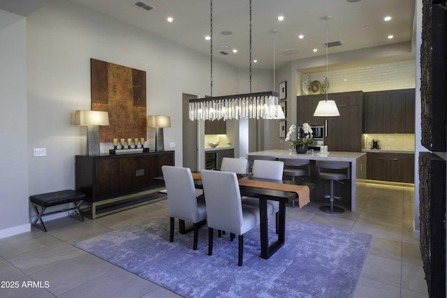 dining room with light tile patterned flooring and a towering ceiling