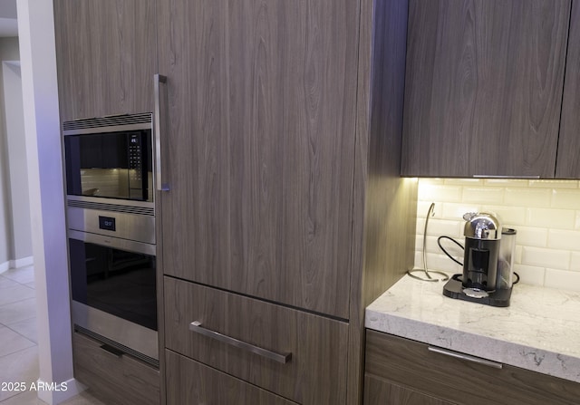 kitchen with light stone counters, stainless steel appliances, and decorative backsplash