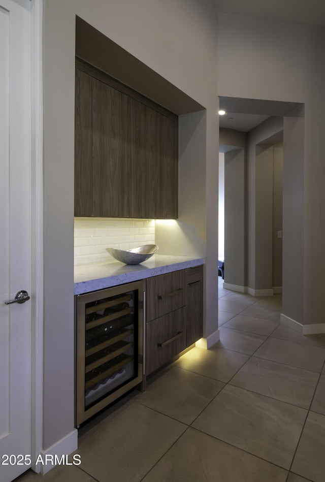 bar featuring wine cooler, light tile patterned flooring, and backsplash