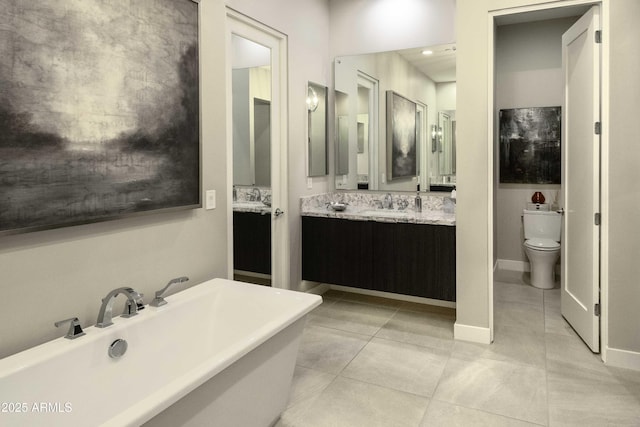 bathroom featuring tile patterned floors, toilet, vanity, and a tub