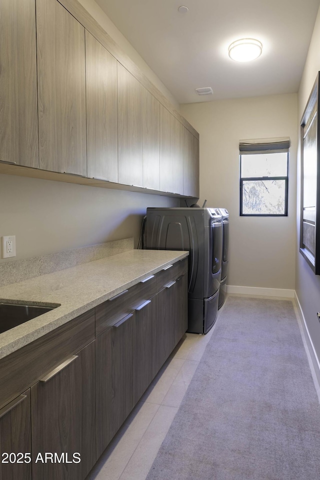 laundry room featuring cabinets, washing machine and clothes dryer, and light tile patterned floors