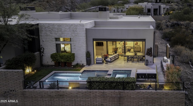 rear view of property featuring a pool with hot tub, an outdoor hangout area, and a patio area