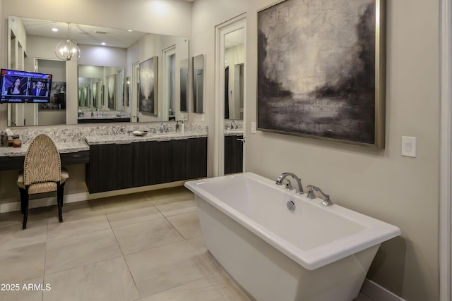 bathroom featuring tile patterned flooring, a tub to relax in, vanity, and a notable chandelier