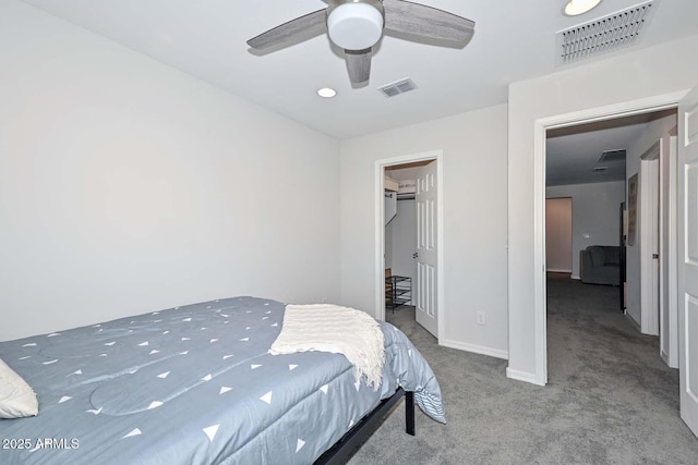 carpeted bedroom with a walk in closet, ceiling fan, and a closet