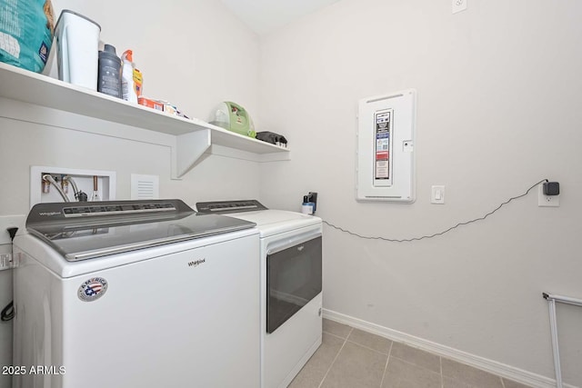 washroom featuring washing machine and clothes dryer, electric panel, and light tile patterned floors