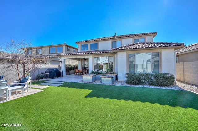 rear view of property with a yard, a patio area, and ceiling fan