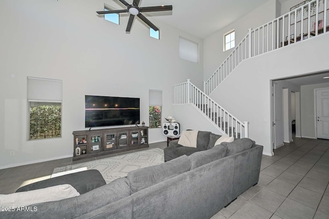 living room with a towering ceiling, tile patterned floors, and ceiling fan