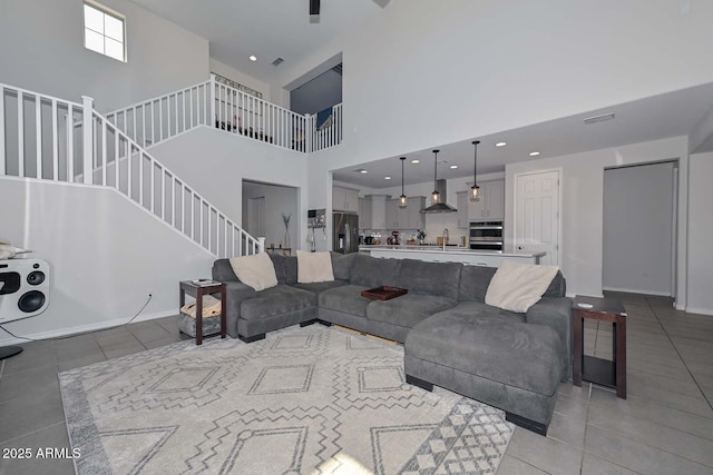 tiled living room featuring sink and a high ceiling