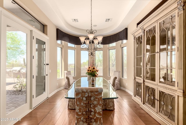 dining area featuring a chandelier, hardwood / wood-style floors, and healthy amount of natural light