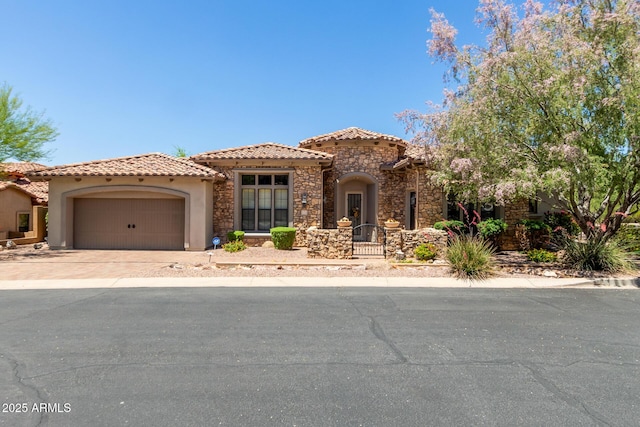 mediterranean / spanish house featuring stucco siding, stone siding, a garage, driveway, and a tile roof