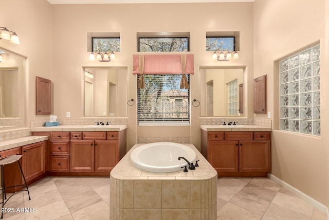 full bathroom featuring a bath, tile patterned floors, two vanities, and decorative backsplash
