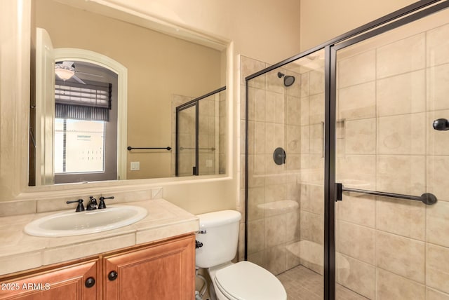 full bathroom featuring a stall shower, toilet, and vanity