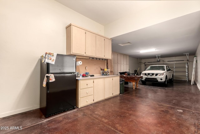garage with freestanding refrigerator and baseboards